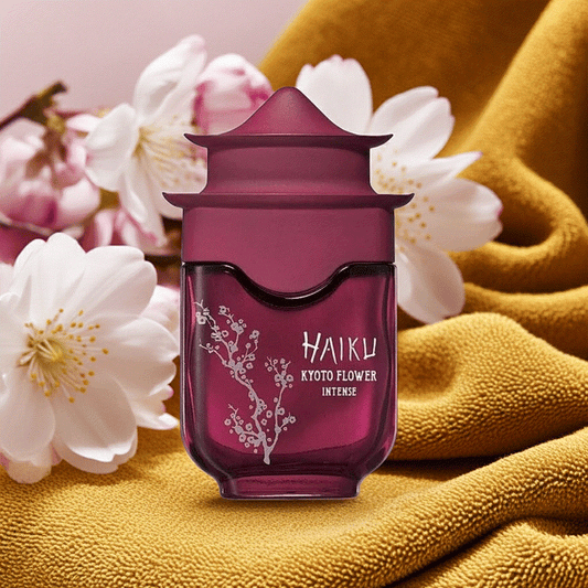Haiku Kyoto Flower Intense perfume bottle with floral design and soft blossoms on mustard fabric background