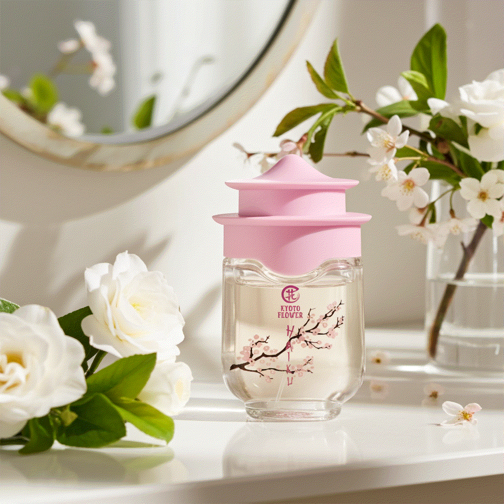 Kyoto Flower Haiku perfume bottle with pink cap surrounded by white flowers on table