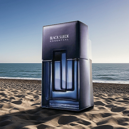 Black Suede Essentials men's cologne bottle on sandy beach with ocean background
