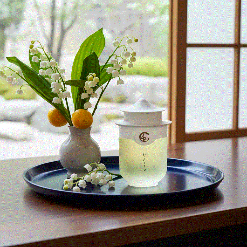 Avon Haiku Original Eau De Perfume bottle with floral vase on tray in serene indoor setting