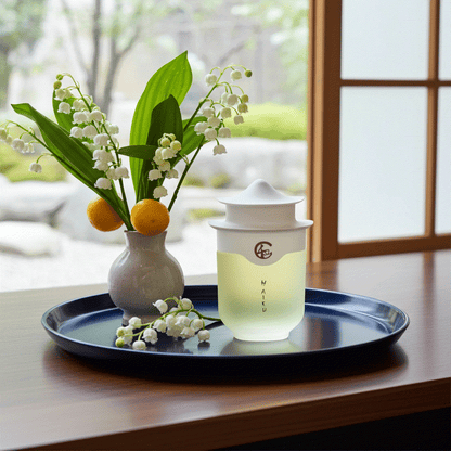 Avon Haiku Original Eau De Perfume bottle with floral vase on tray in serene indoor setting